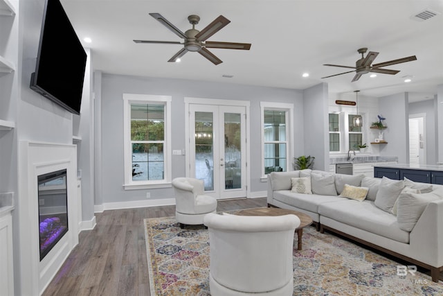 living room with ceiling fan, french doors, and light hardwood / wood-style flooring