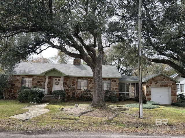 ranch-style home with a garage and a front lawn