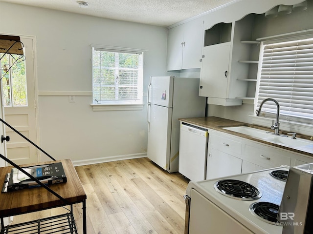 kitchen featuring sink, light hardwood / wood-style flooring, a textured ceiling, white appliances, and white cabinets