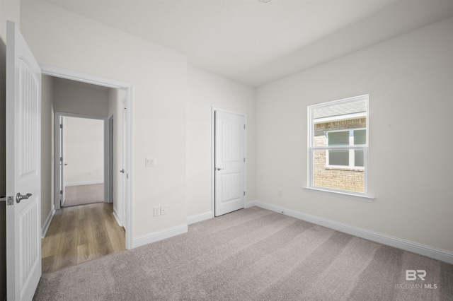 unfurnished bedroom featuring carpet floors and baseboards