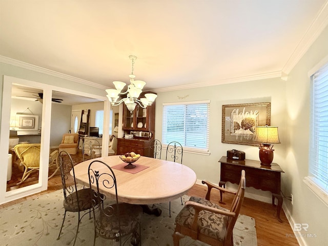 dining room with a chandelier, crown molding, and wood finished floors