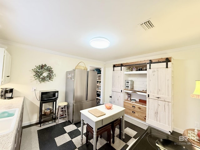 dining area with visible vents, ornamental molding, a barn door, and dark floors