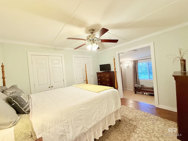 bedroom with ceiling fan, wood finished floors, baseboards, and ornamental molding