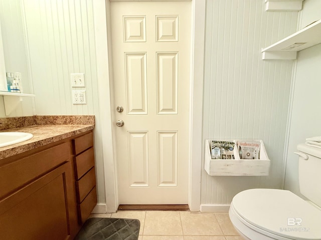 half bath with vanity, tile patterned floors, and toilet