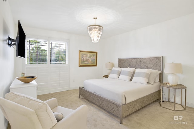 bedroom with a notable chandelier, light colored carpet, and baseboards