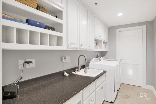 washroom featuring a sink, cabinet space, recessed lighting, and washer and dryer