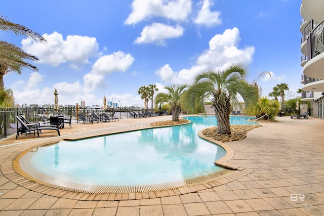 pool with a patio and fence