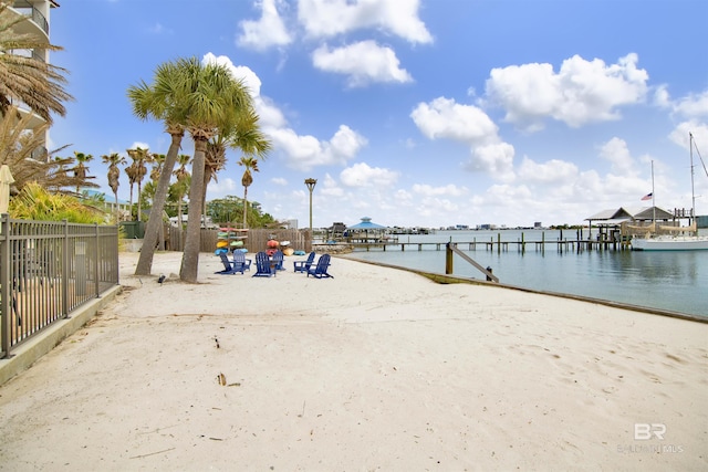 exterior space featuring a dock, a water view, and fence