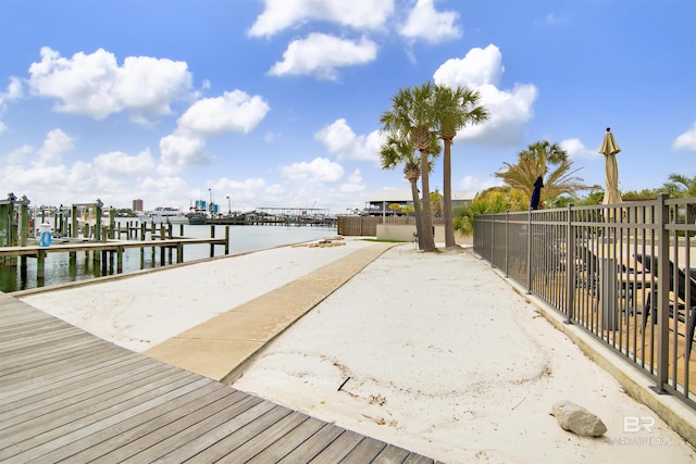 view of dock featuring a water view and fence