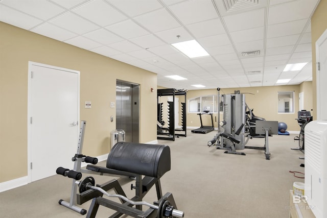 workout area with elevator, a paneled ceiling, and visible vents