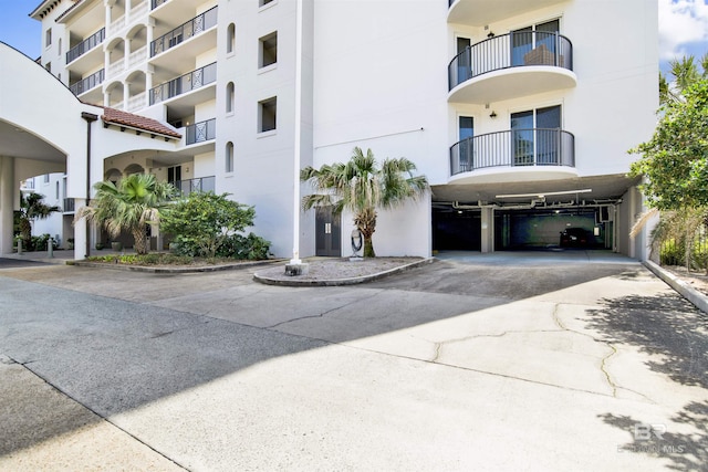 view of building exterior with a carport and concrete driveway