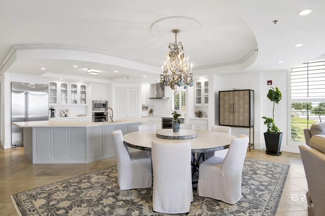 dining space featuring recessed lighting, an inviting chandelier, a tray ceiling, and ornamental molding