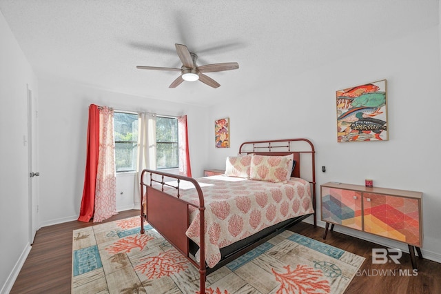 bedroom featuring a textured ceiling, ceiling fan, and dark hardwood / wood-style floors