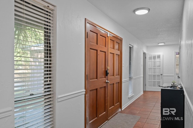 foyer with light tile patterned floors and a textured ceiling