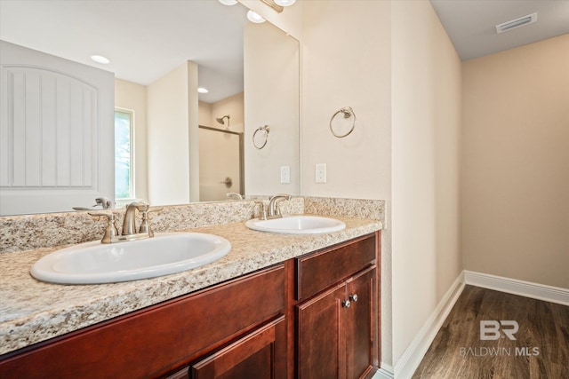 bathroom featuring hardwood / wood-style floors, vanity, and a shower with shower door