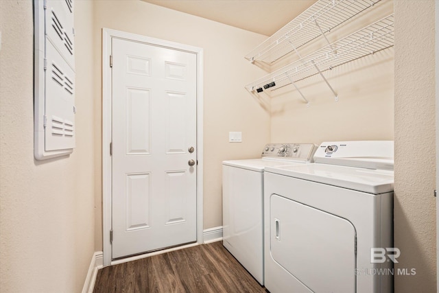 clothes washing area featuring washing machine and dryer and dark hardwood / wood-style floors