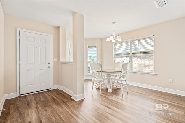 unfurnished dining area featuring hardwood / wood-style floors and a notable chandelier