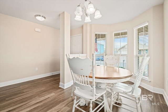 dining space with dark wood-type flooring and a notable chandelier