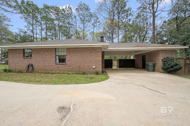 ranch-style house featuring a carport, brick siding, and driveway