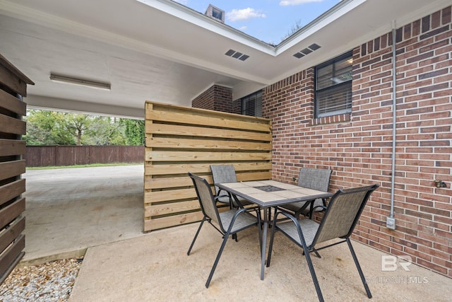 view of patio featuring outdoor dining area and fence