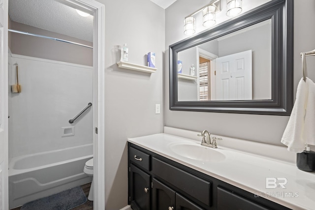 bathroom featuring toilet, bathing tub / shower combination, a textured ceiling, and vanity