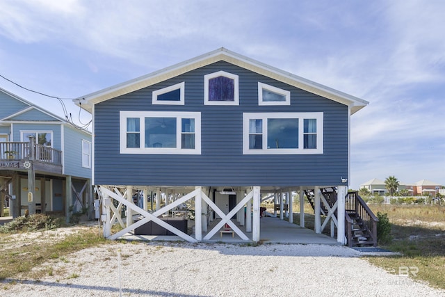 coastal home with driveway, stairway, and a carport