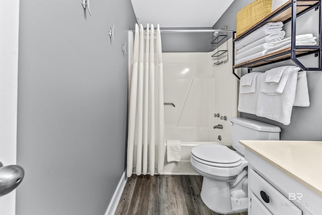 bathroom featuring baseboards, toilet, shower / tub combo with curtain, wood finished floors, and vanity