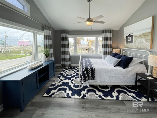 bedroom featuring vaulted ceiling, dark wood-type flooring, a ceiling fan, and baseboards