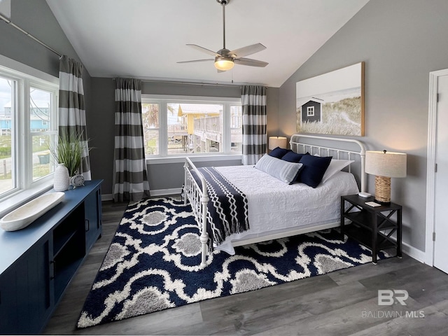 bedroom featuring vaulted ceiling, multiple windows, and dark wood finished floors