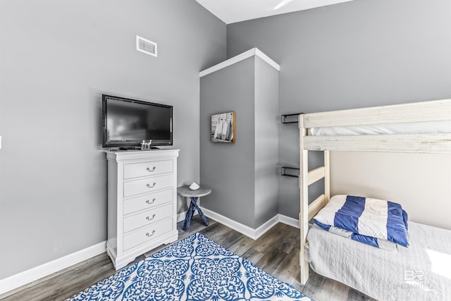 bedroom featuring dark wood-style flooring, visible vents, and baseboards