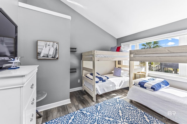 bedroom featuring lofted ceiling, baseboards, and dark wood-type flooring