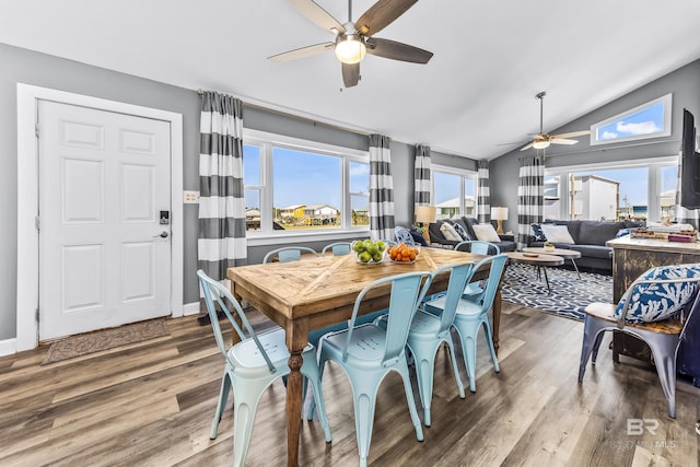 dining area featuring lofted ceiling, ceiling fan, baseboards, and wood finished floors