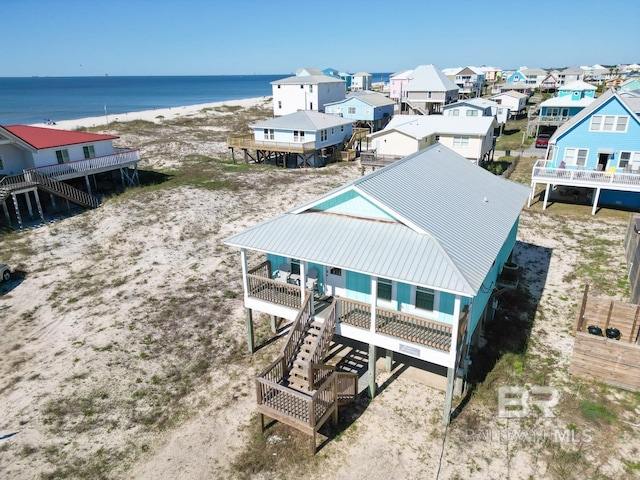 drone / aerial view featuring a water view and a beach view