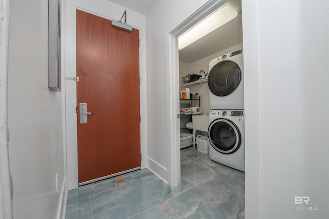 laundry room featuring stacked washer / drying machine