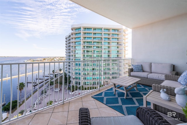 balcony with an outdoor living space and a water view