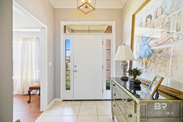 entryway with light hardwood / wood-style flooring, crown molding, and a chandelier