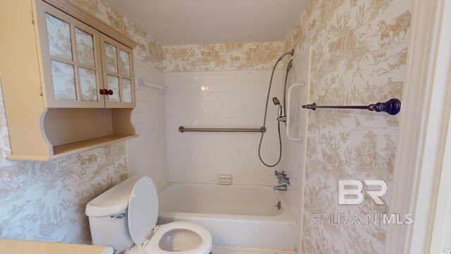 bathroom with tiled shower / bath combo and toilet