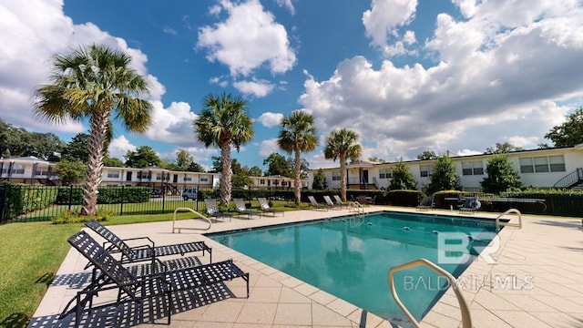 view of pool featuring a lawn and a patio area