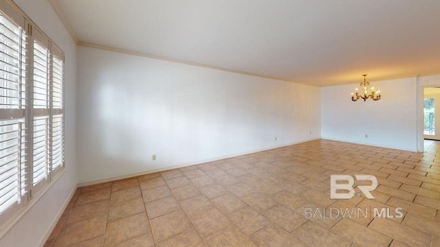 tiled empty room featuring crown molding and a notable chandelier