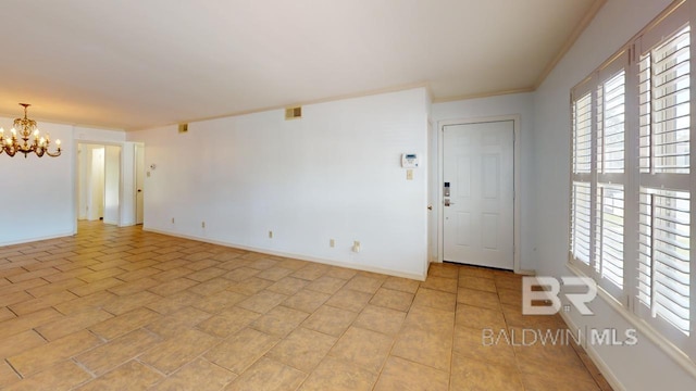 unfurnished room featuring ornamental molding and a notable chandelier