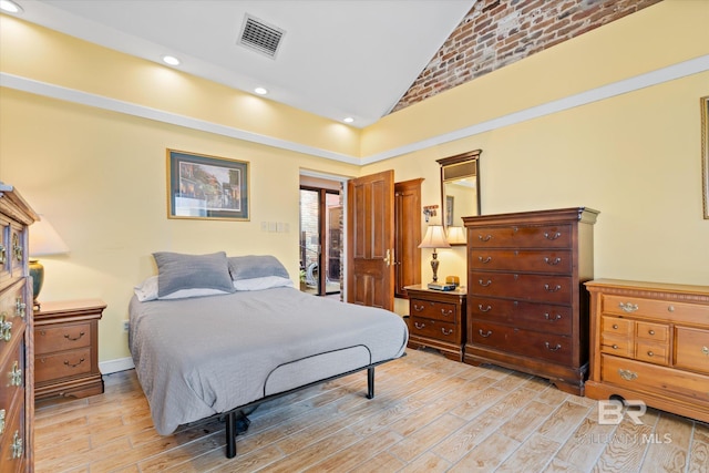 bedroom with light wood-type flooring and high vaulted ceiling