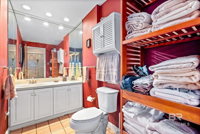 bathroom featuring walk in shower, vanity, toilet, and tile patterned floors