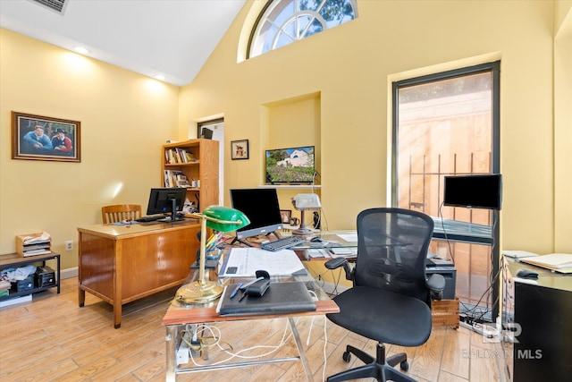 office featuring light hardwood / wood-style flooring and high vaulted ceiling