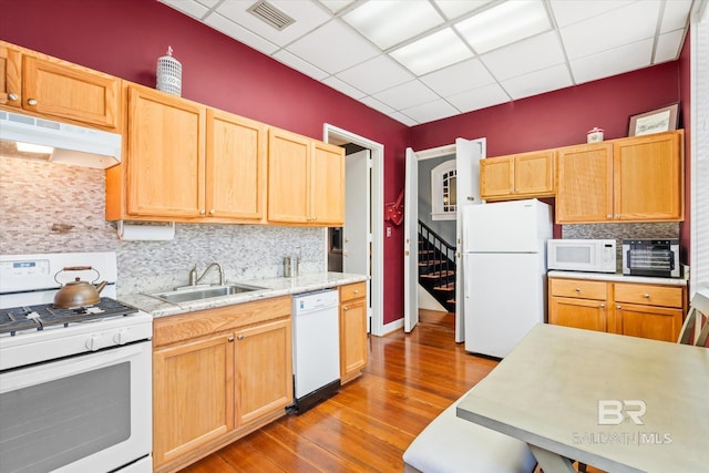 kitchen featuring backsplash, white appliances, sink, and light hardwood / wood-style flooring