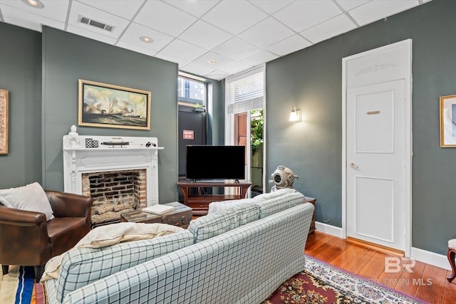 living room featuring a drop ceiling and hardwood / wood-style flooring