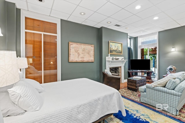 bedroom featuring a drop ceiling, a closet, and a fireplace