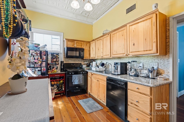 kitchen featuring sink, light wood-type flooring, ornamental molding, and black appliances