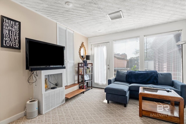 living room featuring a textured ceiling and light colored carpet