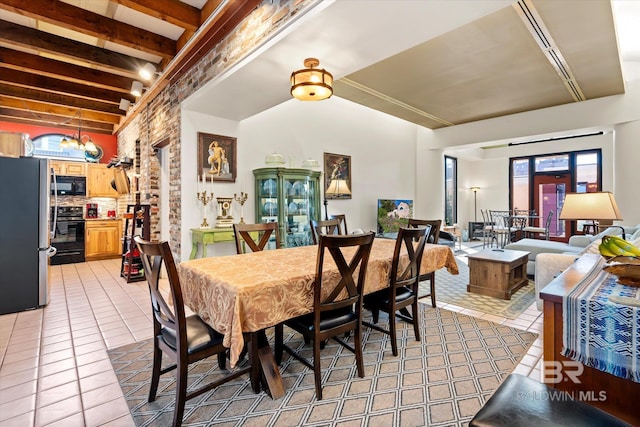 dining room featuring beamed ceiling and light tile patterned floors