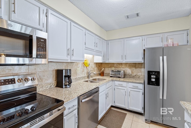 kitchen featuring tasteful backsplash, visible vents, appliances with stainless steel finishes, and a sink